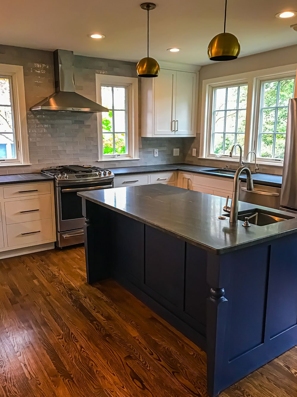 navy wooden kitchen countertop with white cabinets and ceramic backsplash