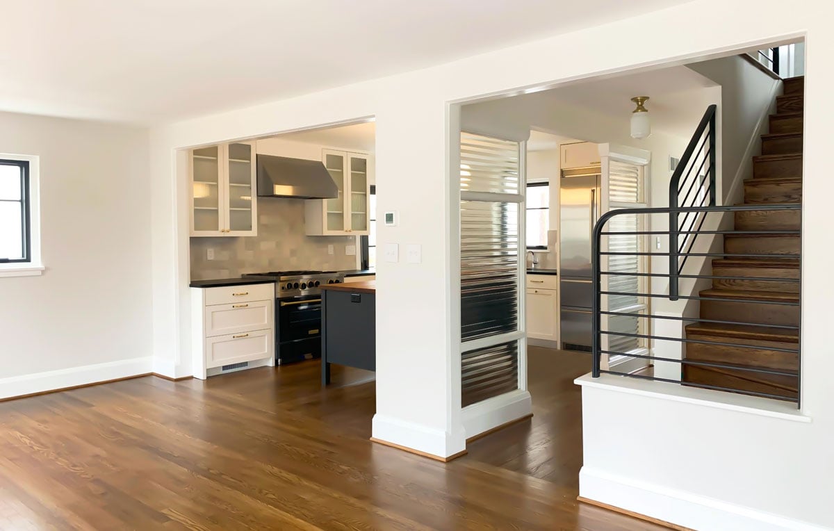 Open dining floor plan with walkways to the kitchen. Black metal railings