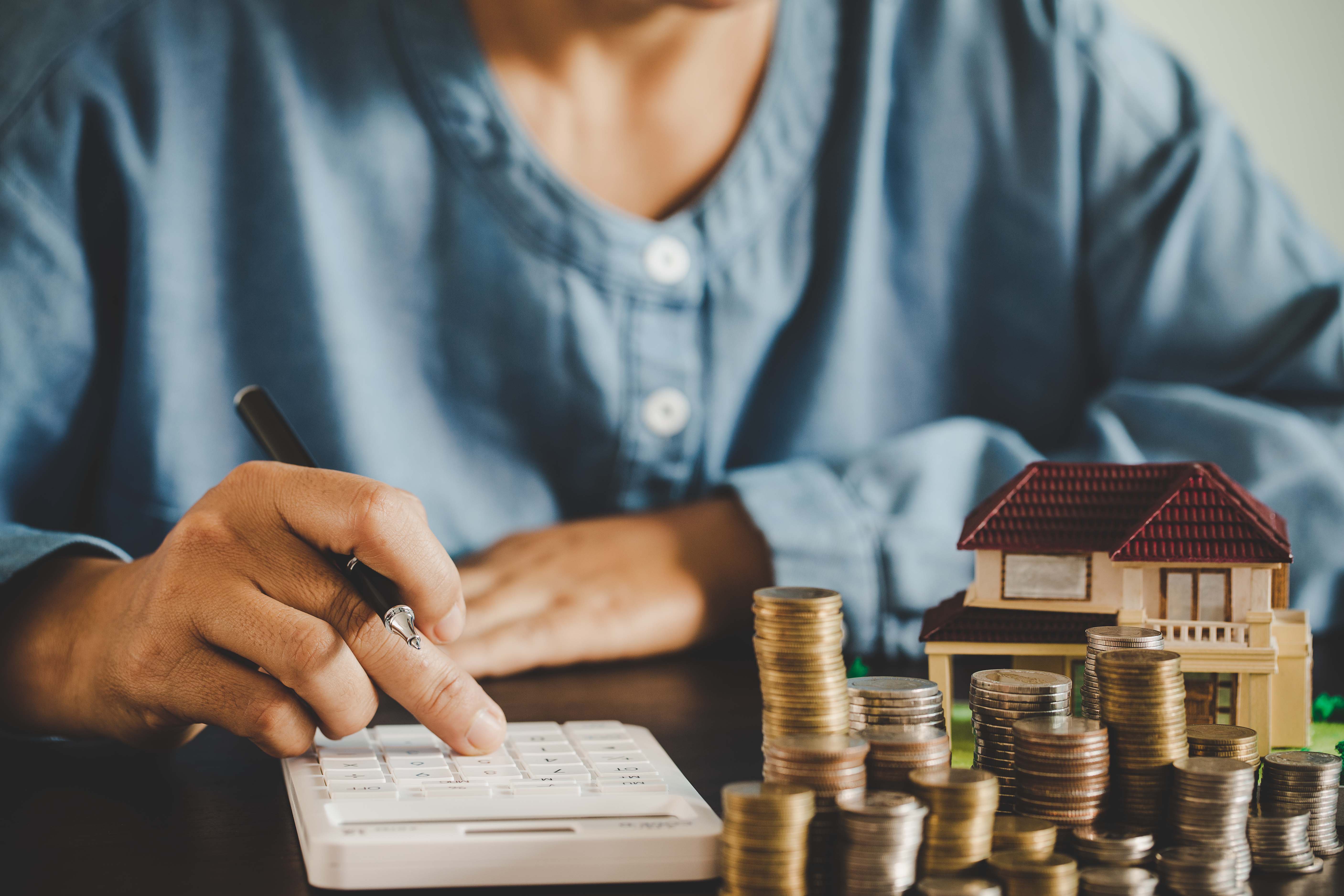 Person using a calculator to determine the cost of a construction project.