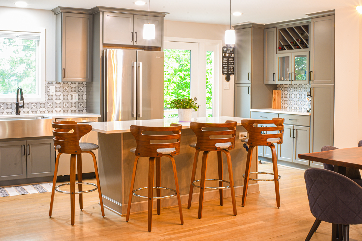 Kitchen with wooden high-back island seating and geometric backsplash kitchen remodel