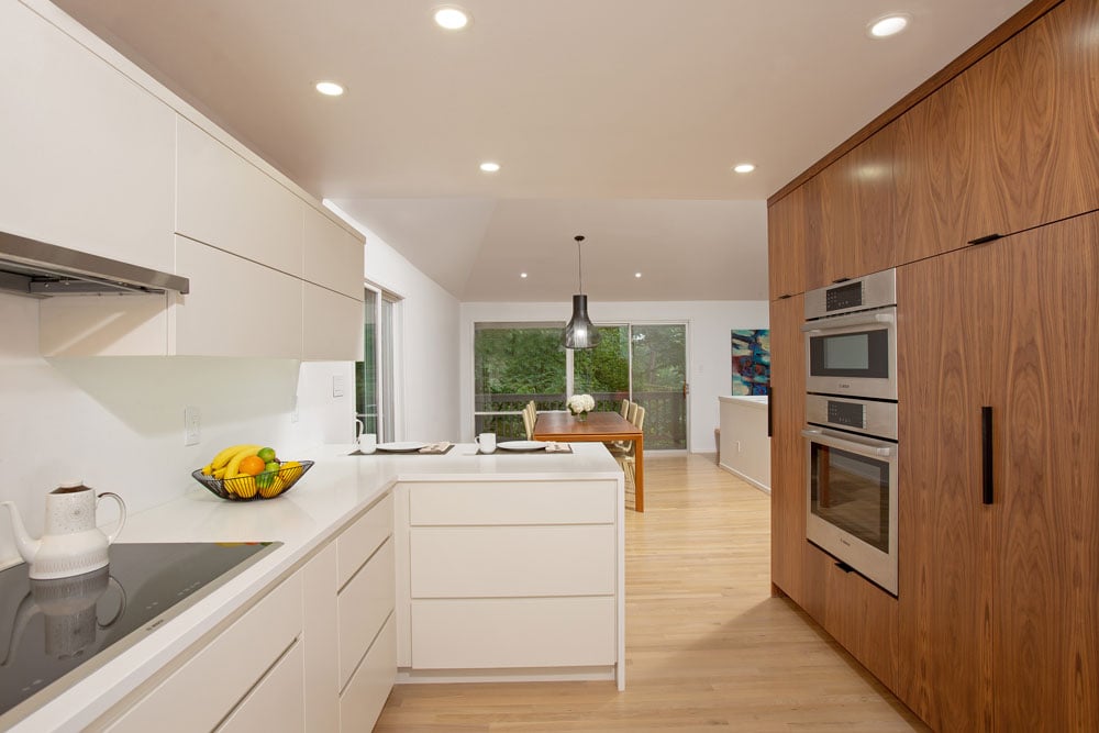 U-shaped kitchen counter with ceiling-high kitchen cabinetry on the right