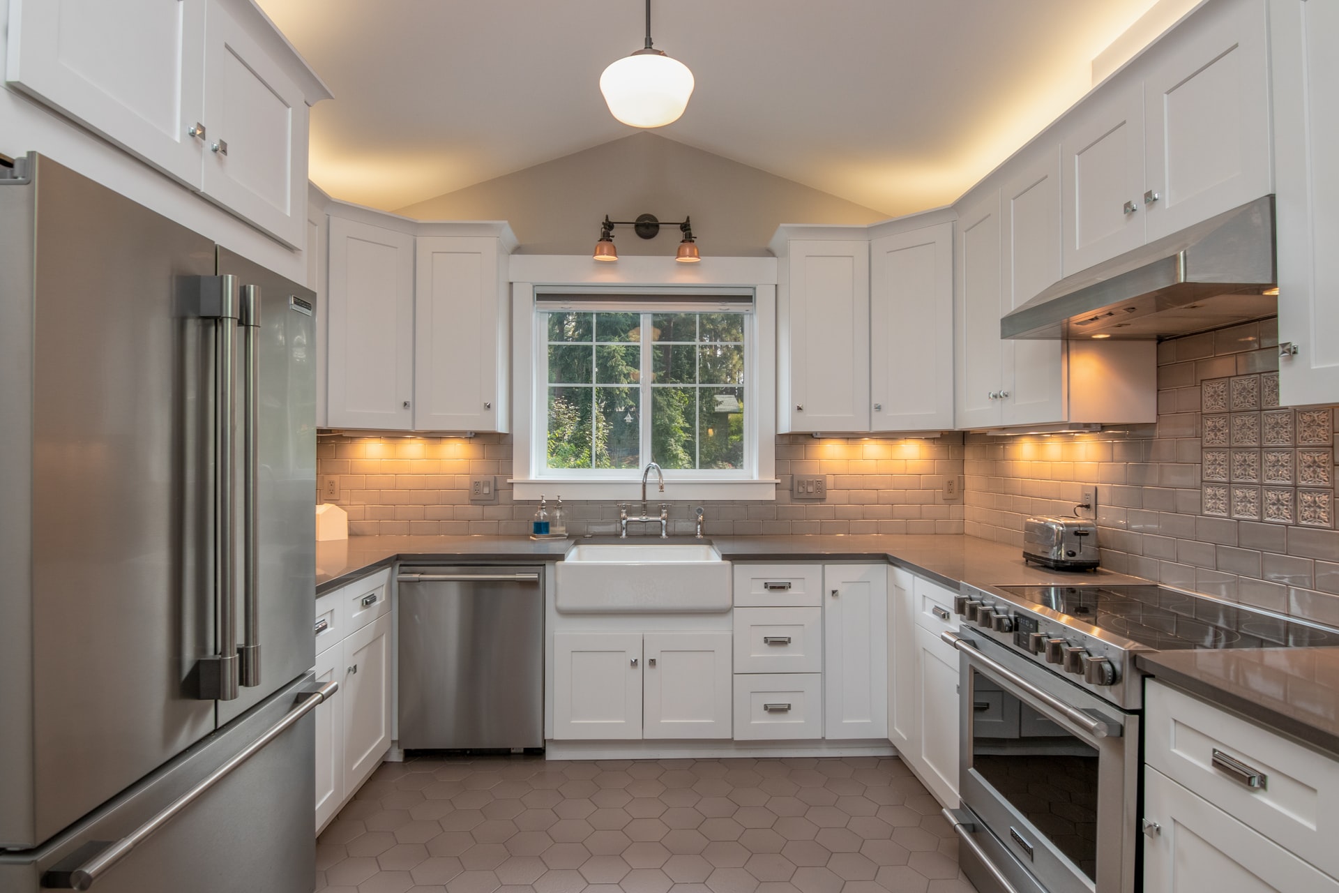 Kitchen remodel with white storage space and stainless steel appliances