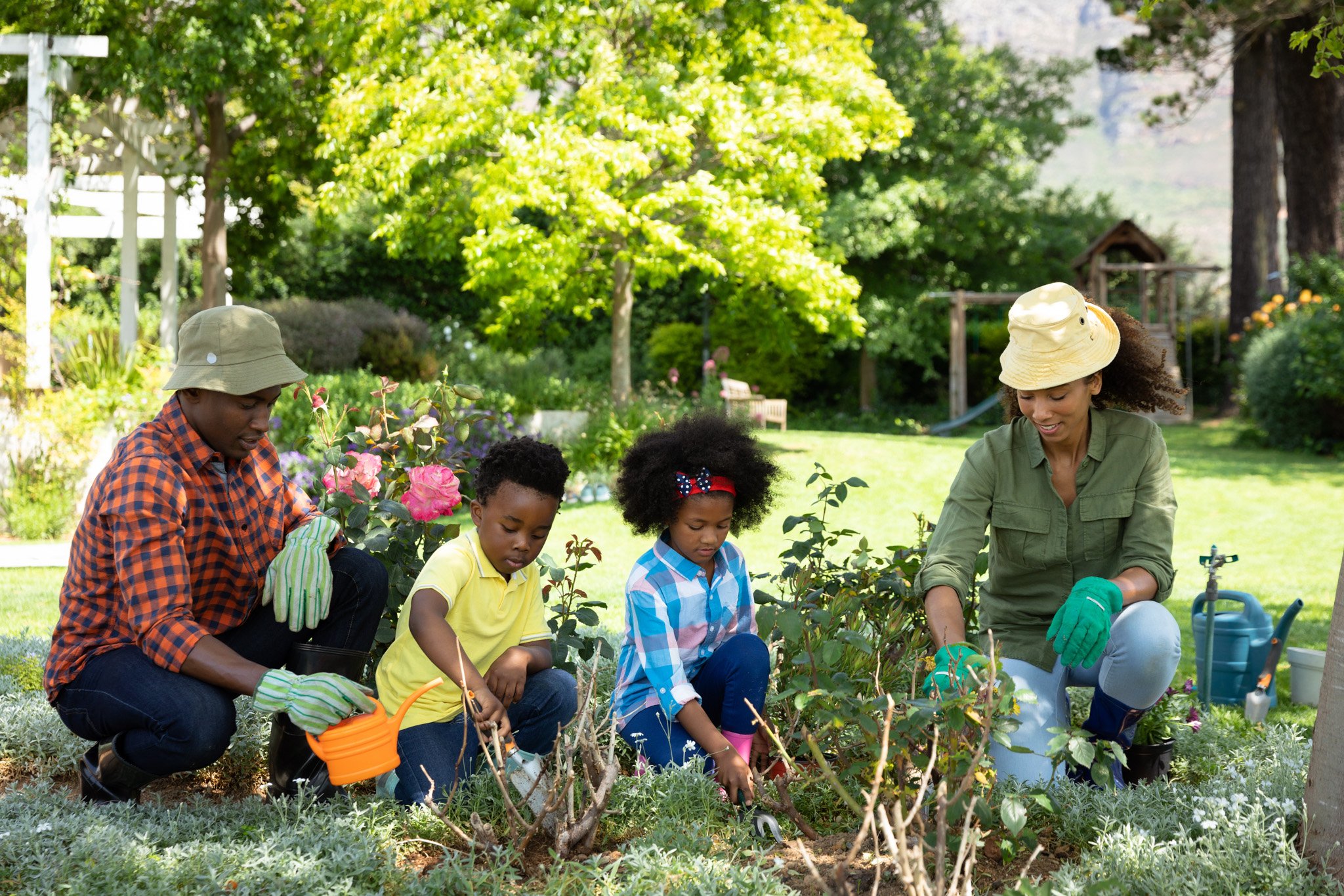 A family of four gardening at their home.