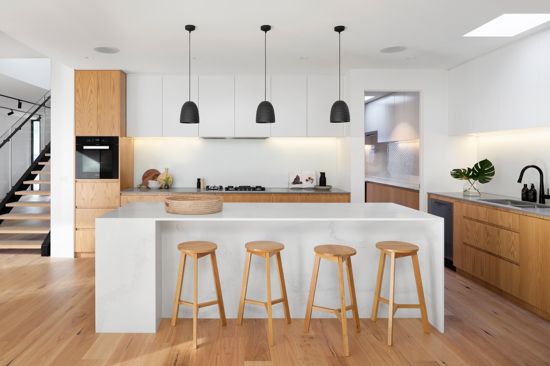 Kitchen with pale wood stools and hard wood flooring