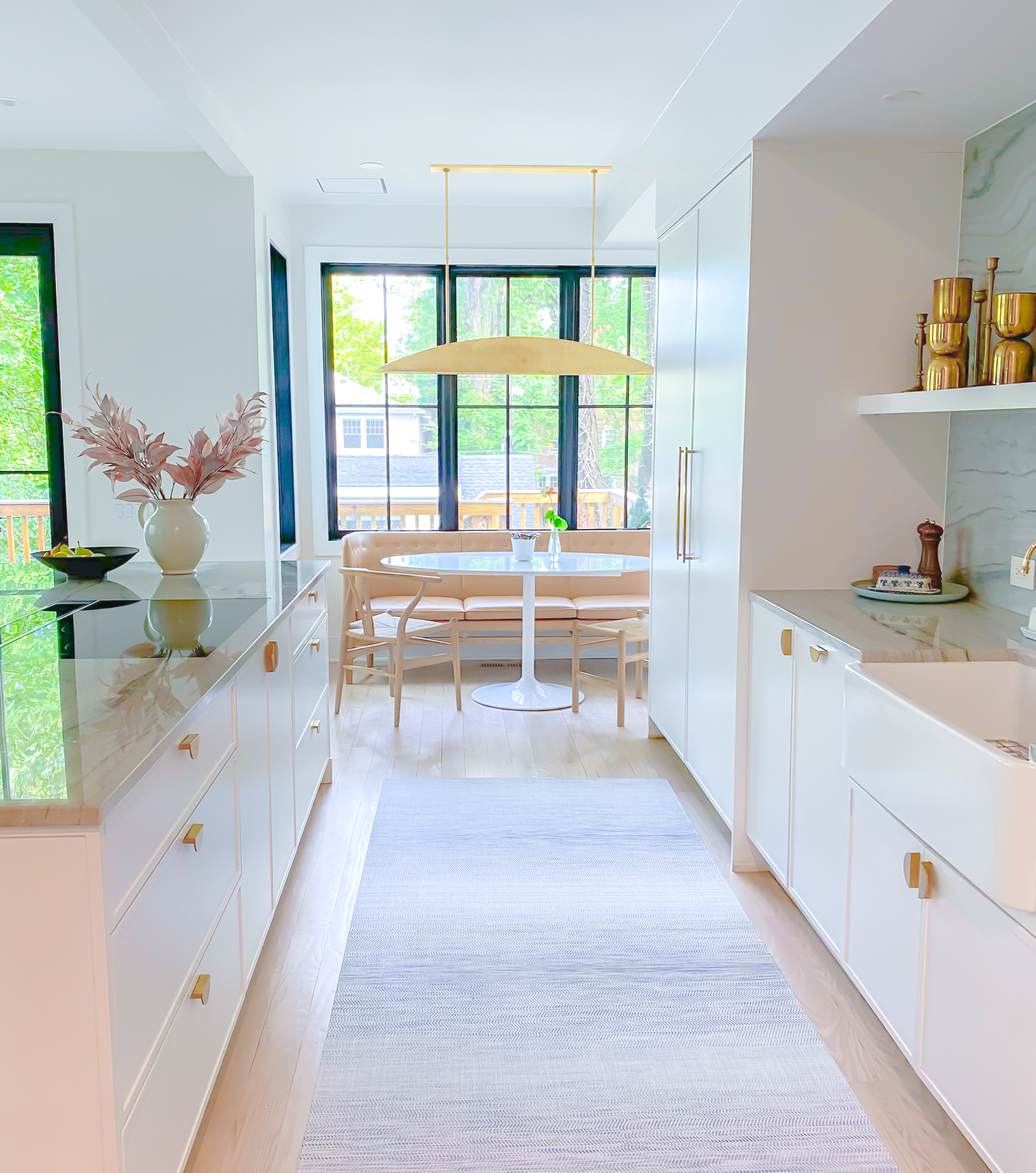 photo of a bright and airy kitchen and eating nook renovation in washington, dc that includes sleek modern white cabinetry and quartzite stone countertops
